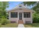 Charming, light pink home featuring a screened-in porch with brick-lined stairs and a well-maintained yard at 459 Bell Ave, Brooksville, FL 34601