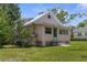 Charming cottage style home with a metal roof surrounded by lush greenery at 459 Bell Ave, Brooksville, FL 34601