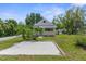 Charming single Gathering home with a concrete driveway situated on a lush green lawn, under a clear blue sky at 459 Bell Ave, Brooksville, FL 34601