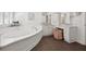 Bright primary bathroom features an oval tub, dark tile flooring, vanity, and makeup area at 460 Althea Rd, Belleair, FL 33756