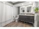 Modern bathroom featuring floating dual sink vanity, hardwood floors, and shower with curtain at 460 Althea Rd, Belleair, FL 33756