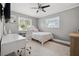 Bright bedroom featuring a fan, hardwood floors, and a desk area at 460 Althea Rd, Belleair, FL 33756