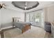 Bright bedroom features a tray ceiling, French doors, and a ceiling fan at 460 Althea Rd, Belleair, FL 33756