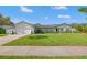 Inviting single-story home featuring a manicured lawn, white brick accents, and a neutral color palette at 460 Althea Rd, Belleair, FL 33756