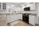 Well-lit kitchen features white cabinets, granite countertops, and stainless steel appliances at 460 Althea Rd, Belleair, FL 33756