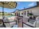 Beautiful outdoor patio with stylish furniture, umbrella, and lush landscaping near the pool at 460 Althea Rd, Belleair, FL 33756