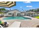 Beautiful pool area with brick paving, surrounded by lush landscaping and patio furniture at 460 Althea Rd, Belleair, FL 33756