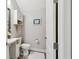 Bright half bathroom features a pedestal sink, beach art, and gray walls at 4653 Ancona Way, Wesley Chapel, FL 33543