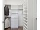 Walk-in closet featuring custom white shelving and drawers for optimal organization and storage solutions at 4653 Ancona Way, Wesley Chapel, FL 33543