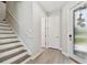 A stairway and front door entryway lead into the home with wood-style floors at 4653 Ancona Way, Wesley Chapel, FL 33543