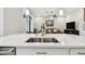 A stunning kitchen island features a modern stainless steel sink and pendant lighting at 4653 Ancona Way, Wesley Chapel, FL 33543