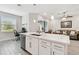 The kitchen island has a modern sink, dishwasher, and white cabinets and countertops at 4653 Ancona Way, Wesley Chapel, FL 33543