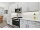 Featuring stainless steel oven and microwave, with white cabinets and countertops at 4653 Ancona Way, Wesley Chapel, FL 33543