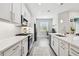 Bright kitchen featuring stainless steel appliances, white cabinets, and quartz countertops at 4653 Ancona Way, Wesley Chapel, FL 33543