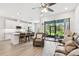 Bright open-concept living space flows seamlessly into the kitchen with views of a screened lanai at 4653 Ancona Way, Wesley Chapel, FL 33543