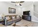 Comfortable living room with a leather sofa, ceiling fan, and a view of the staircase at 4653 Ancona Way, Wesley Chapel, FL 33543