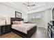 Spacious bedroom with wood floors, tray ceiling, and a bed with dark wood trim at 4653 Ancona Way, Wesley Chapel, FL 33543