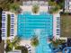Aerial view of a large community pool with palm trees and ample lounge seating at 4653 Ancona Way, Wesley Chapel, FL 33543