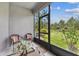 Relaxing screened patio with wicker furniture and view of lush green lawn at 4653 Ancona Way, Wesley Chapel, FL 33543