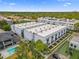 This aerial view showcases modern townhomes with lush greenery, city views, and a community pool at 5008 S Macdill Ave # 16, Tampa, FL 33611