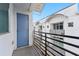 This balcony has black railings and wood-look floors, providing a view of neighboring buildings and clear sky at 5008 S Macdill Ave # 16, Tampa, FL 33611