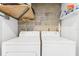 Functional laundry area equipped with side-by-side machines and overhead storage shelving at 5008 S Macdill Ave # 16, Tampa, FL 33611