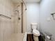 Walk-in shower with beige tile, shower head, hand bar, and a matching toilet at 5603 80Th N St # 103, St Petersburg, FL 33709