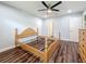 Bedroom featuring hardwood floors, a ceiling fan, unfinished wooden furniture, and an open door to a walk-in closet at 5603 80Th N St # 103, St Petersburg, FL 33709
