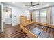 Bedroom with hardwood floors, ceiling fan, and two windows with curtains, plus a glimpse of the en suite bathroom at 5603 80Th N St # 103, St Petersburg, FL 33709