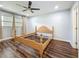 A view of a bedroom with hardwood floors, a ceiling fan, two windows, and unfinished wooden furniture at 5603 80Th N St # 103, St Petersburg, FL 33709