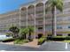 Three story condominium with arched entry and American flag on display at 5603 80Th N St # 103, St Petersburg, FL 33709