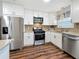 Updated kitchen features white cabinets, stainless steel appliances, granite countertops, and stylish tile backsplash at 5603 80Th N St # 103, St Petersburg, FL 33709