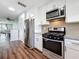 Bright kitchen with stainless steel appliances, granite countertops, and wood flooring at 5603 80Th N St # 103, St Petersburg, FL 33709