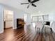 Bright living room with dark wood floors, ceiling fan, and a dining area with table and four chairs at 5603 80Th N St # 103, St Petersburg, FL 33709