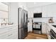 Well-lit kitchen boasts stainless steel appliances, white cabinetry, and hardwood floors at 5633 Puerta Del Sol S Blvd # 204, St Petersburg, FL 33715