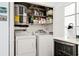 Functional laundry room with washer, dryer, shelving, and convenient mini beverage cooler at 5633 Puerta Del Sol S Blvd # 204, St Petersburg, FL 33715
