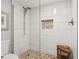 Modern walk-in shower with white tile, pebble flooring, and mosaic niche detailing at 5633 Puerta Del Sol S Blvd # 204, St Petersburg, FL 33715