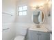 Bathroom featuring beadboard paneling and a round mirror at 5847 Harrison St, New Port Richey, FL 34653