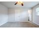 Cozy bedroom features neutral carpeting, a ceiling fan, and ample natural light at 5847 Harrison St, New Port Richey, FL 34653