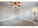 Bright bedroom featuring neutral carpet, a ceiling fan, and an ensuite bathroom at 5847 Harrison St, New Port Richey, FL 34653