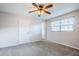 Inviting carpeted bedroom includes a ceiling fan and natural light from the window at 5847 Harrison St, New Port Richey, FL 34653