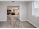 Bright living room featuring wood-look floors and an open view into the kitchen with modern appliances at 5847 Harrison St, New Port Richey, FL 34653