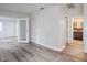 Open living area featuring light wood flooring, a french door and access to the bathroom at 5847 Harrison St, New Port Richey, FL 34653
