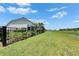 Sprawling lawn in backyard with black metal fence and view of the pond at 5971 Hidden Branch Dr, Apollo Beach, FL 33572