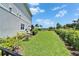 Lush backyard with neatly manicured lawn, garden beds, and seating area, creating a serene outdoor space at 5971 Hidden Branch Dr, Apollo Beach, FL 33572