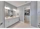 Bright bathroom featuring double sinks, tile floors and a walk-in closet at 5971 Hidden Branch Dr, Apollo Beach, FL 33572