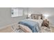 Comfortable bedroom with soft blue accents, featuring a bed with a starfish pillow and stylish nightstands at 5971 Hidden Branch Dr, Apollo Beach, FL 33572