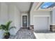Inviting home entryway featuring a modern front door, brick walkway, and attached garage at 5971 Hidden Branch Dr, Apollo Beach, FL 33572