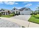 Charming home featuring a gray brick driveway, a two-car garage, and lovely landscaping at 5971 Hidden Branch Dr, Apollo Beach, FL 33572