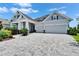Beautiful home exterior featuring a brick driveway, a two-car garage, and colorful landscaping at 5971 Hidden Branch Dr, Apollo Beach, FL 33572